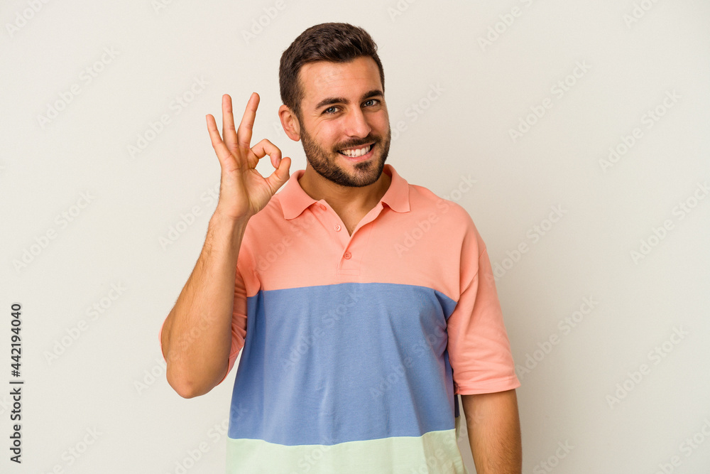 Young caucasian man isolated on white background cheerful and confident showing ok gesture. Young caucasian man isolated on white background cheerful and confident showing ok gesture.