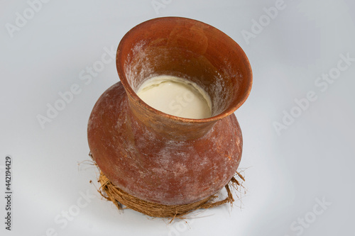 A Traditional clay pot of curd or yogurt placed on coconut fiber base. This hand made mud pot keeps curd cool and cold. it locally called Doi er hari or Doi er bhando. popular yogurt pot of Bangladesh
