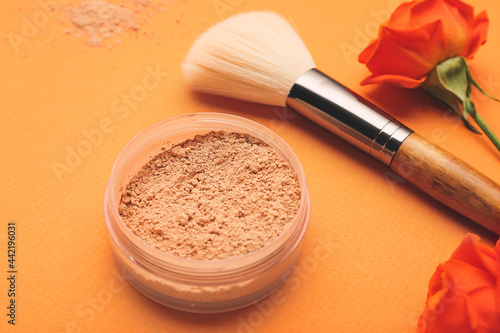 Composition with makeup brush and powder on color background