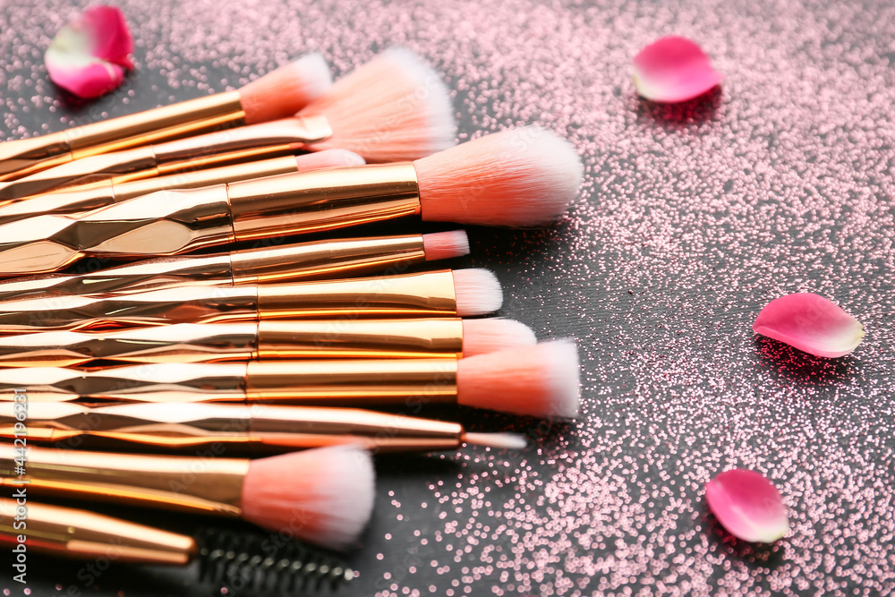 Naklejka premium Composition with makeup brushes on dark background