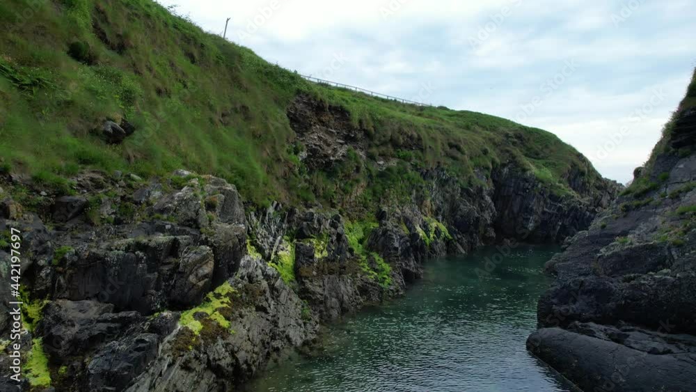 Low altitude flight above water between 2 cliffs leading up to the sea in Dundeady Island near Rosscarbery, County Cork, Ireland Low altitude flight above water between 2 cliffs leading up to the sea in Dundeady Island near Rosscarbery, County Cork, Ireland