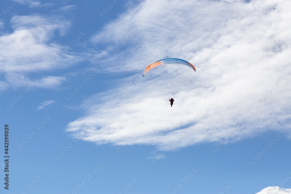 Adventurous People Flying on a Paraglider around the mountains. Savona, British Columbia, Canada. Adventurous People Flying on a Paraglider around the mountains. Savona, British Columbia, Canada.
