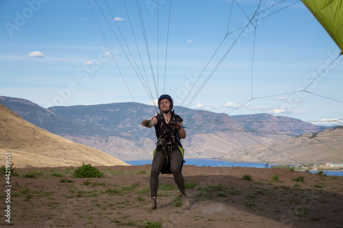Adventurous Caucasian Woman learning to Fly on a Paraglider around the Canadian mountains. Savona, British Columbia, Canada