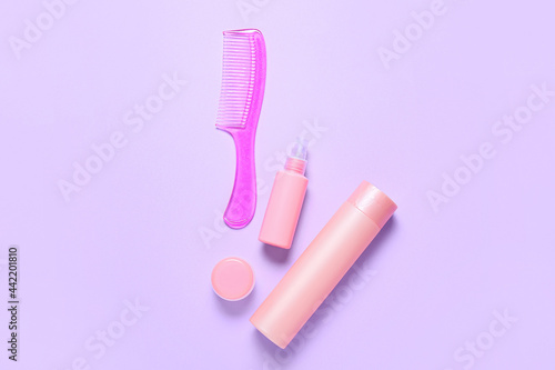 Hair comb and cosmetics on color background