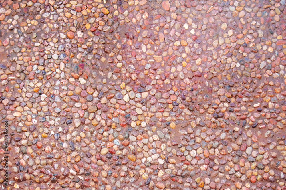 Transparent water flows down the pebbles. Pebble or gravel background or texture. Transparent water flows down the pebbles. Pebble or gravel background or texture.