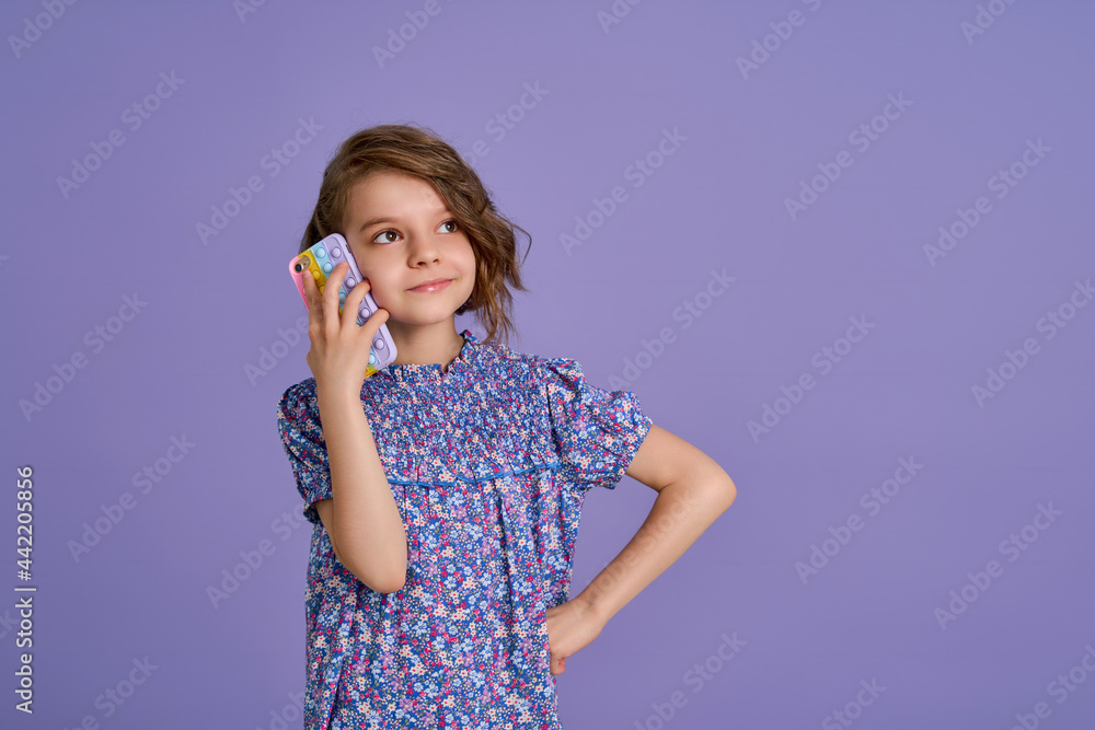Little girl holding telephone isolated over violet color background Little girl holding telephone isolated over violet color background