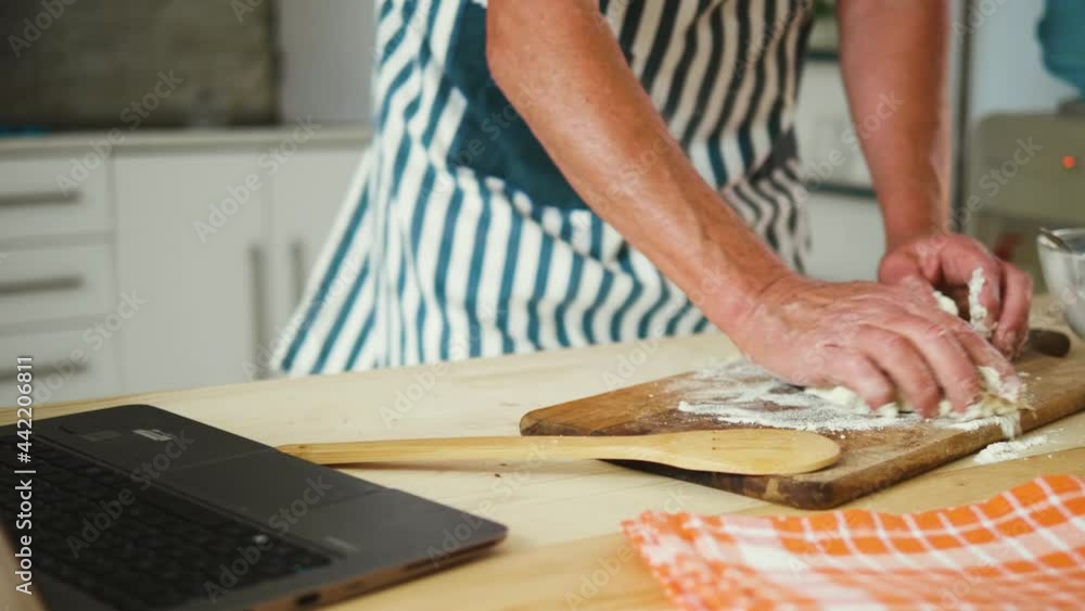 Old man uses internet to learn how to make and knead bread dough Old man uses internet to learn how to make and knead bread dough