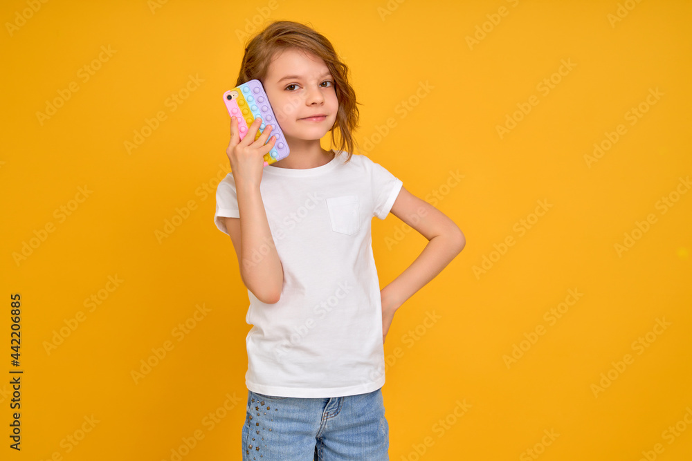 Little girl holding telephone isolated over yellow color background Little girl holding telephone isolated over yellow color background