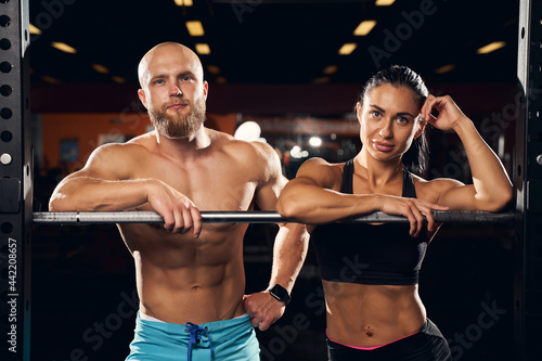 Fotografie Well-built man and his strong girlfriend posing at the gym