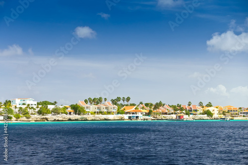 Resort hotel at the waterfront in Kraledijk, Bonaire, Dutch Antilles, Caribbean Sea, with emerald seashore and blue sky