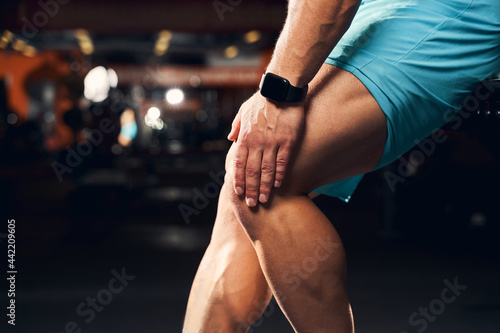 Tired sportsman experiencing discomfort from knee pain