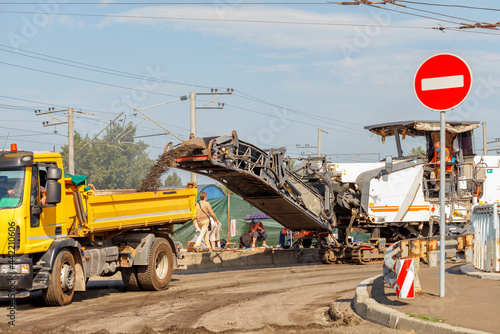 A road milling machine removes the top layer of asphalt from a road section being repaired.