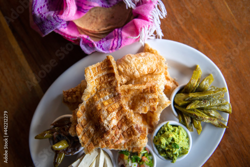 Mexican Pork rind. Nopales and guacamole. Mexican food on wooden background. Traditional Mexican food concept. Mexican chicharrón.