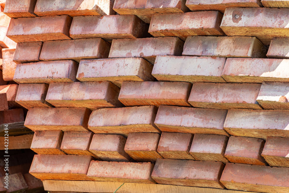 Lot of red ceramic bricks backdrop at construction, building site Lot of red ceramic bricks backdrop at construction, building site
