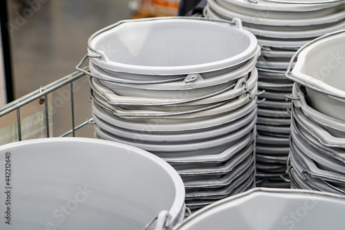 Lot of gray plastic buckets in stacks, in a hardware store