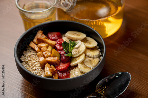Summer fruity oatmeal with honey, berries, banana, apples and cinnamon