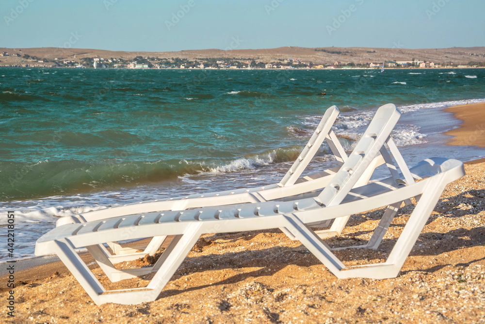 Sun loungers on a sandy beach by the sea