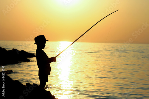 Silhouette of a boy with a fishing rod © Kostia
