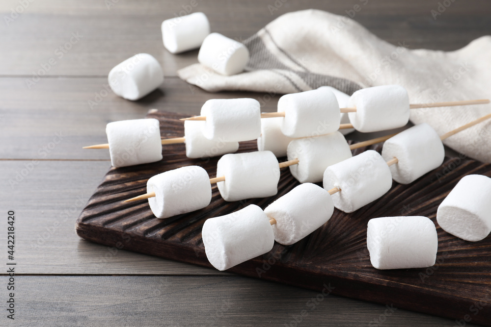 Sticks with sweet marshmallows on wooden table Sticks with sweet marshmallows on wooden table