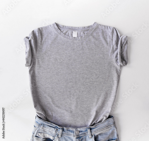 Gray cotton t-shirt with jeans isolated above white background. Mock up flat lay in minimalist style.