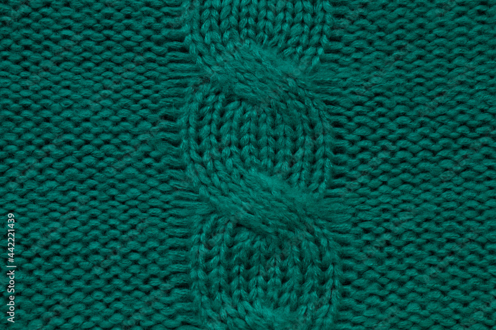 Wool hand-knitted or machine knitting pattern with braids. Knit warm green sweater or scarf. Cozy dark emerald blanket background. Fabric texture close up. Comfortable style cloth. Wool hand-knitted or machine knitting pattern with braids. Knit warm green sweater or scarf. Cozy dark emerald blanket background. Fabric texture close up. Comfortable style cloth.