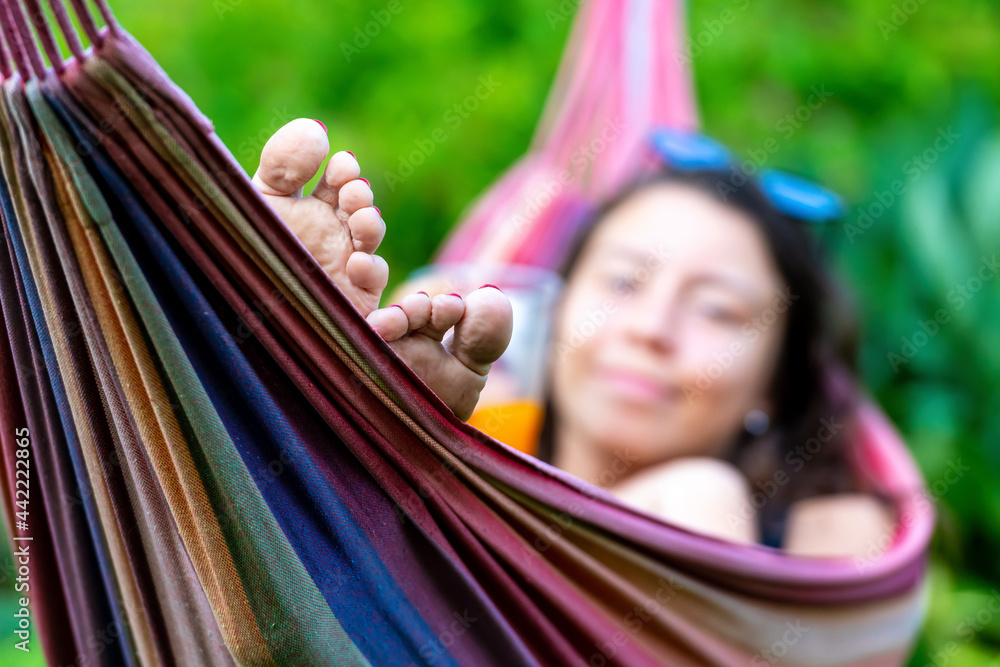 female is chilling and relaxing in the hammock, selective focus, focus on the feet female is chilling and relaxing in the hammock, selective focus, focus on the feet