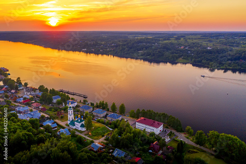 Aerial drone view of ancient russian town Ples on the Volga river with colorful sunset © Nikolay N. Antonov