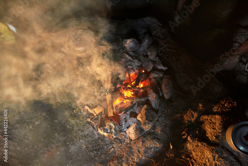 Top view shot of cooking soup in a pot over campfire for dinner in the wild