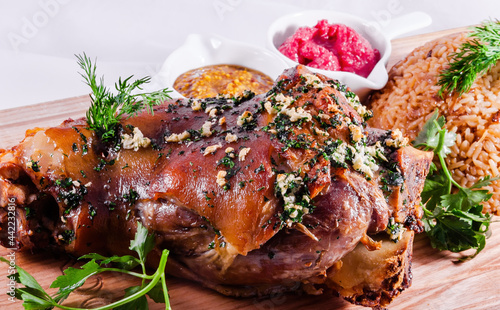 Canvas Print German style roasted pork hock (knuckle, shank) with rice on wooden cutting boar