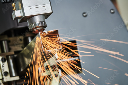 Laser cutting of metal pipe with sparks on tube laser machine