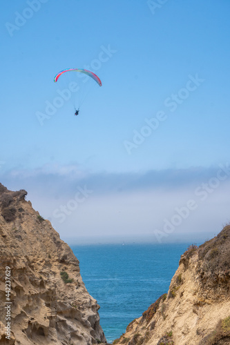 Paraglider by ocean cliffs