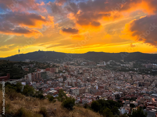 Amazing landscape with dramatic sky over the city with aerial view. Mountain on the horizon in the background at sunset or sunrise. © Bruno