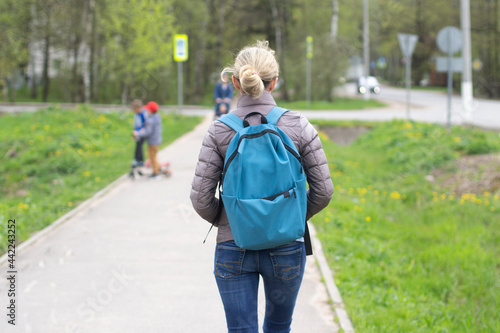 The girl is walking along the road. The woman walks through the city.