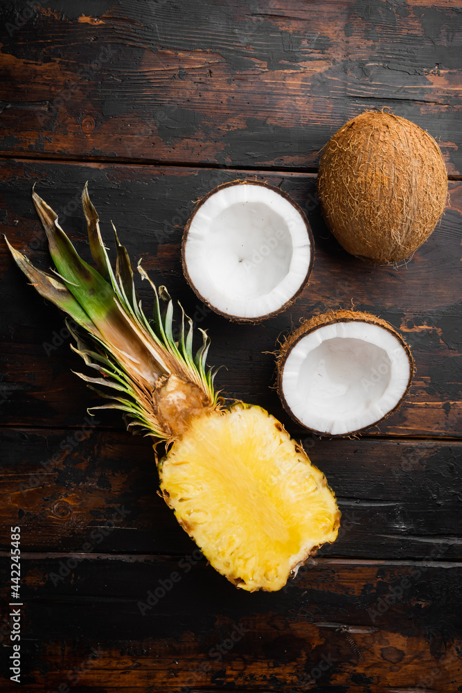 Fresh exotic fruits, pineapple and Coconut, on old dark  wooden table background, top view flat lay