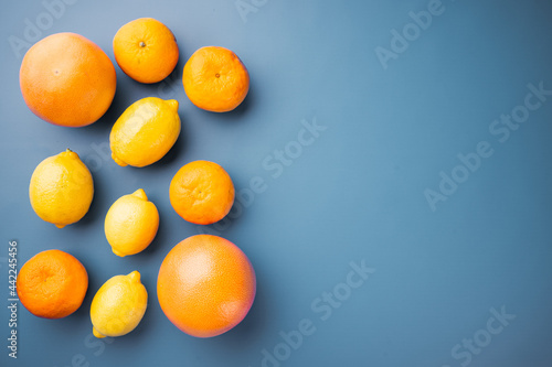 Colorful citrus fruit, on blue textured summer background, top view flat lay, with copy space for text