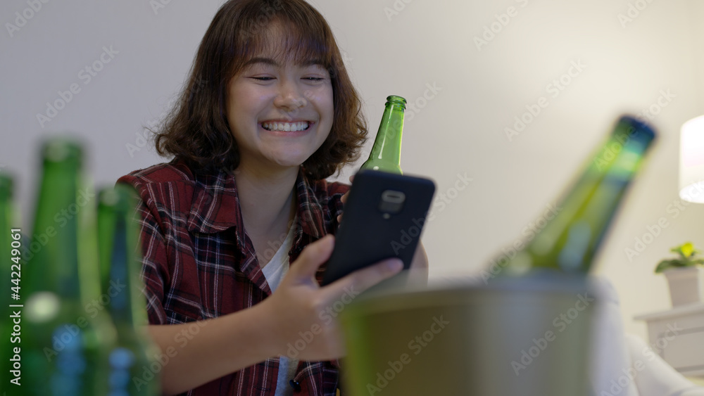 Young happy attractive asia female enjoy smile laugh relax night party event online celebration festive with friends at home sofa couch living room drink beer with glass and bottle online videocall. Young happy attractive asia female enjoy smile laugh relax night party event online celebration festive with friends at home sofa couch living room drink beer with glass and bottle online videocall.