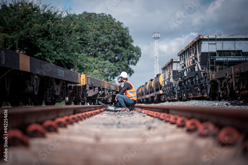 Engineer under inspection and checking construction process railway switch and checking work on railroad station .Engineer wearing safety uniform and safety helmet in work
