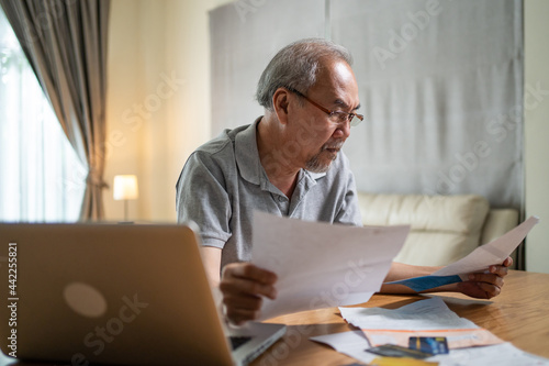 Depressed Asian Senior Elderly male feel worry about financial problem