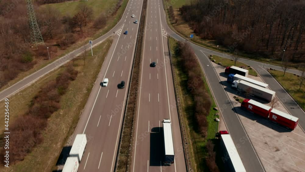 Tilt up reveal of straight highway leading in flat countryside between fields. Flight above road. Traffic and transportation concept. Tilt up reveal of straight highway leading in flat countryside between fields. Flight above road. Traffic and transportation concept.