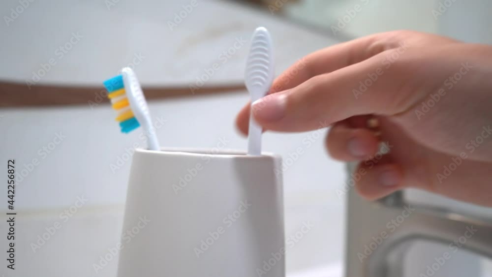 Man hand puts many toothbrushes into plastic glass. 4k stock footage.