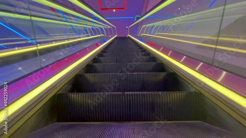 Colorful lights on ascending escalator