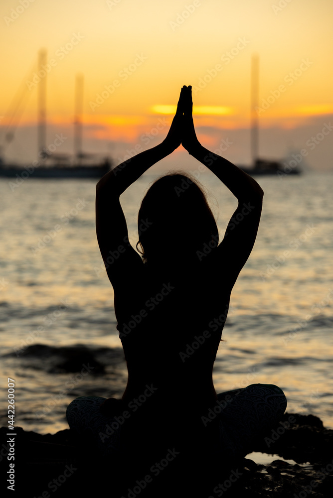 Woman practicing yoga on the beaches of Formentera in Spain