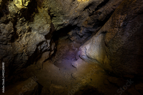 Chandolaz ridge cave in the Primorsky region. A deep cave illuminated by a flashlight.