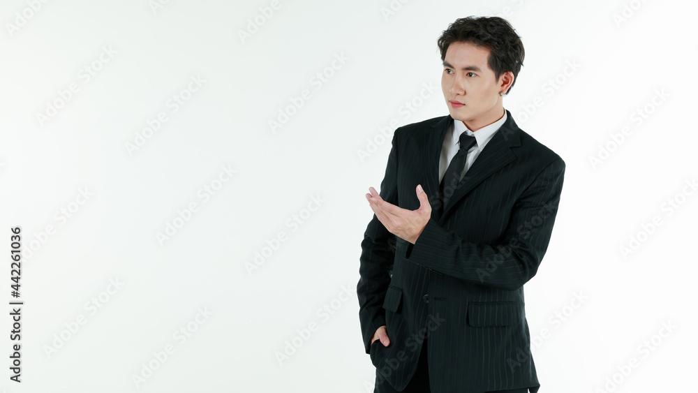 Portrait of self-confidence young and handsome Asian businessman in black suit standing in elegant pose and pointing finger, copy space studio shot isolated on white background Portrait of self-confidence young and handsome Asian businessman in black suit standing in elegant pose and pointing finger, copy space studio shot isolated on white background