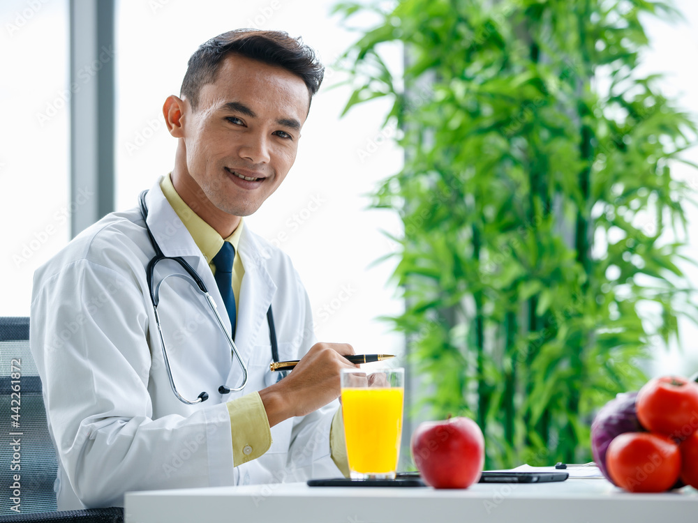 Asian medical practitioner sitting at table with healthy food Asian medical practitioner sitting at table with healthy food