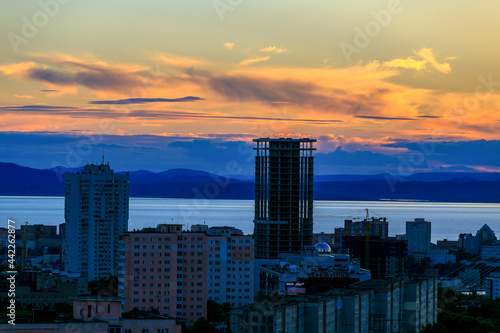 View from above. Silhouettes of tall residential home on the background of sunset in Vladivostok. New residential neighborhood in the sea city.