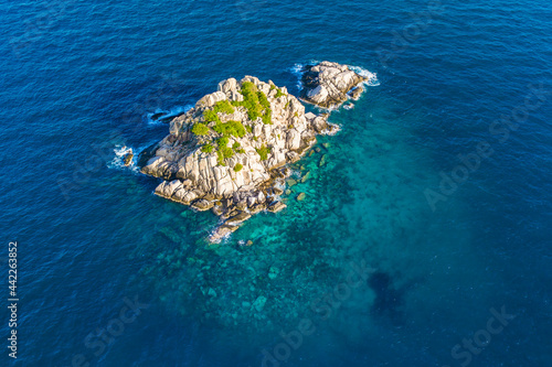 Shark Island off Koh Tao Thailand wide angle drone panorama deep blue ocean with island and long tail boat clouds and coral reef scuba diving