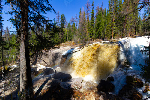 Gorgeous May waterfall in the mountain taiga
