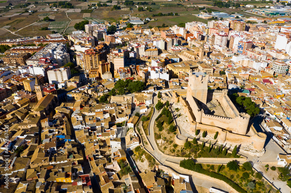 View from drone of cityscape of Villena and medieval moorish Atalaya castle on sunny fall day, Alicante, Spain..