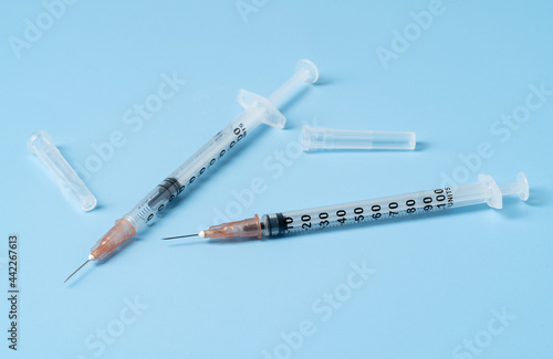 Insulin syringes are placed on a blue background. Vaccination concept